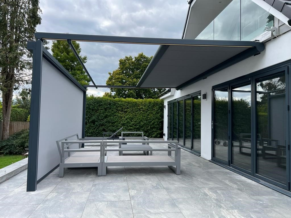 Pergola with a vertical fabric screen lowered at the front